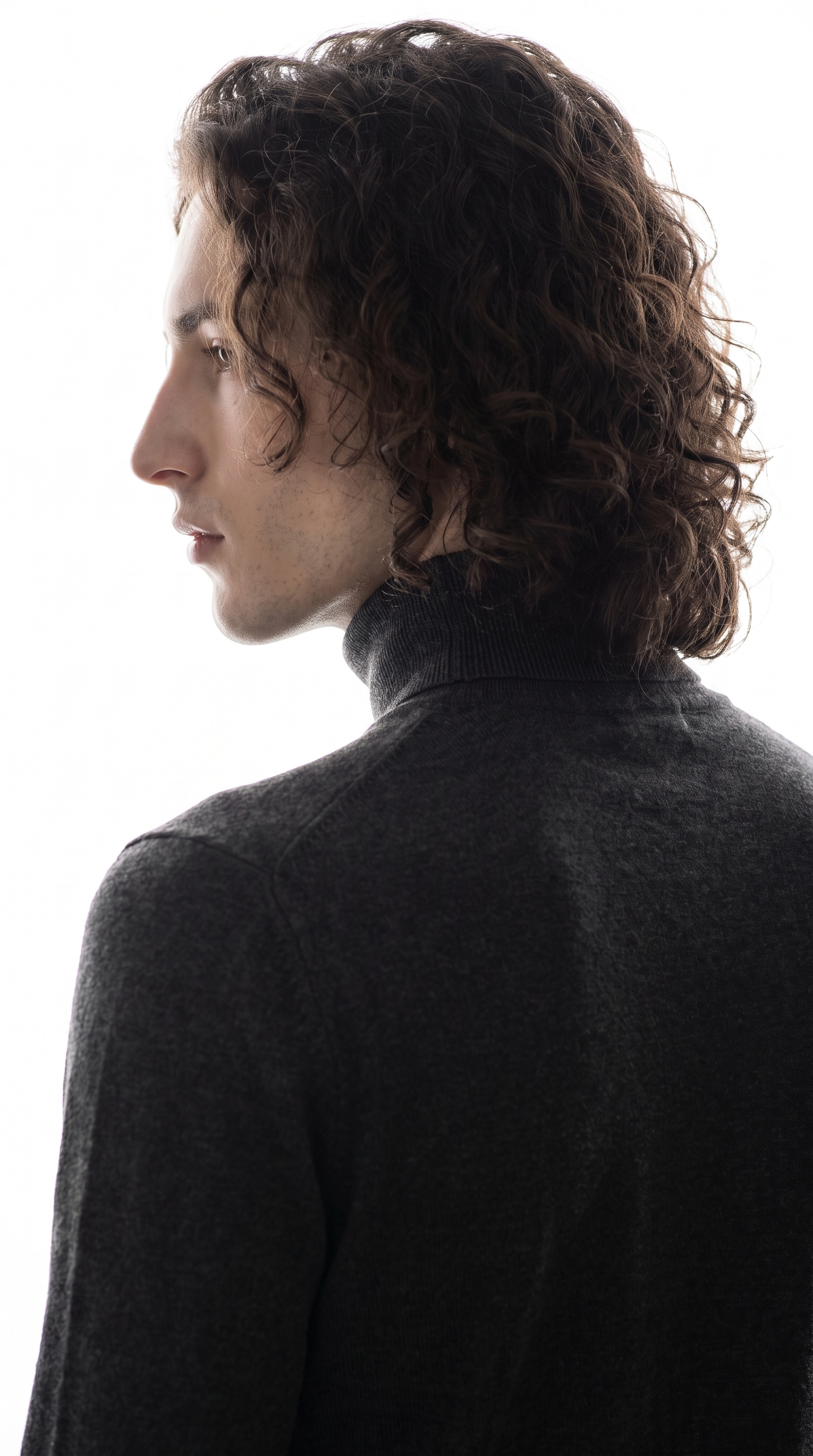 Over-shoulder silhouette in high-key studio light — fashion editorial clean